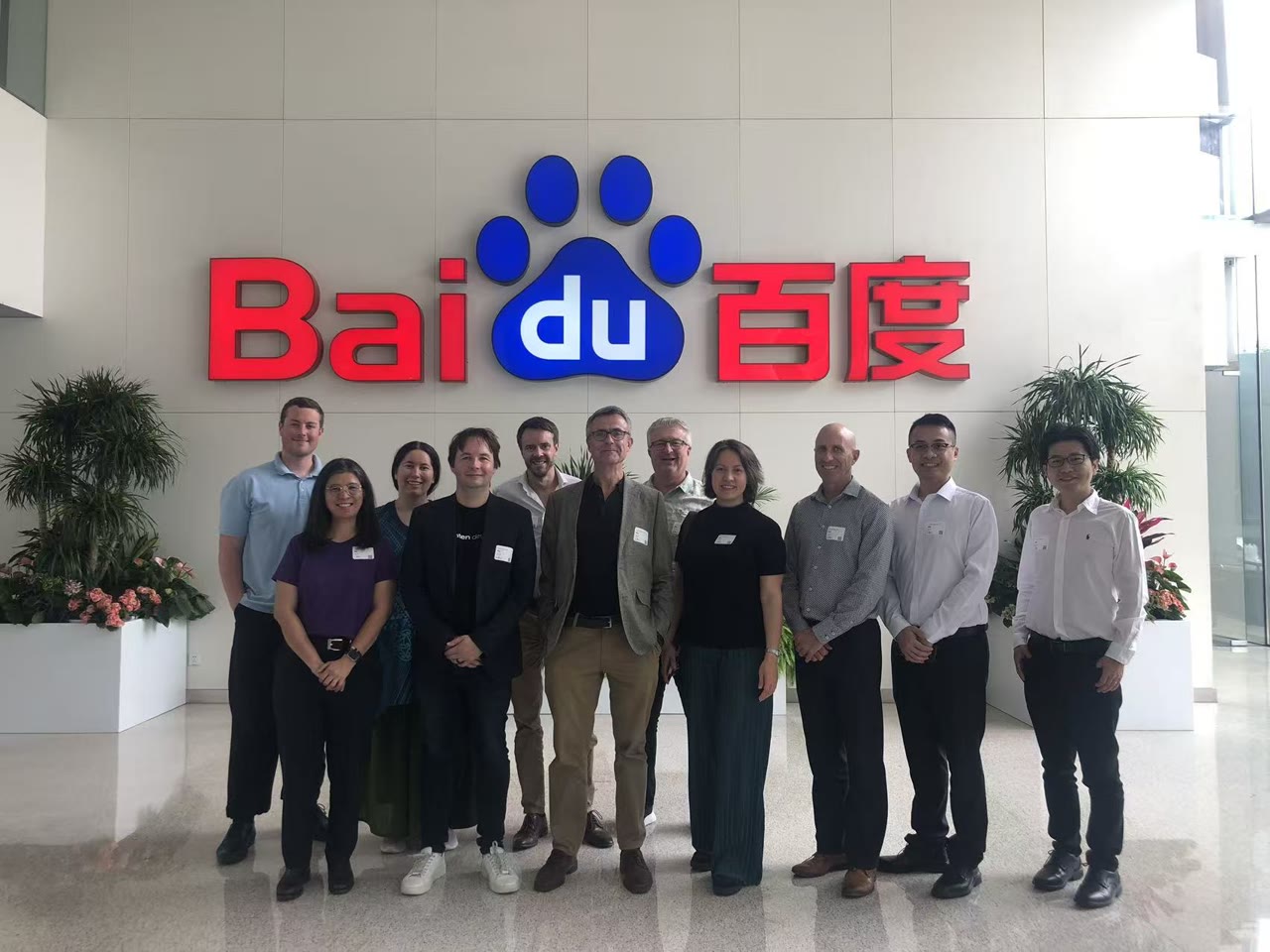 The New Zealand delegation in front of the Baidu logo at Baidu's offices