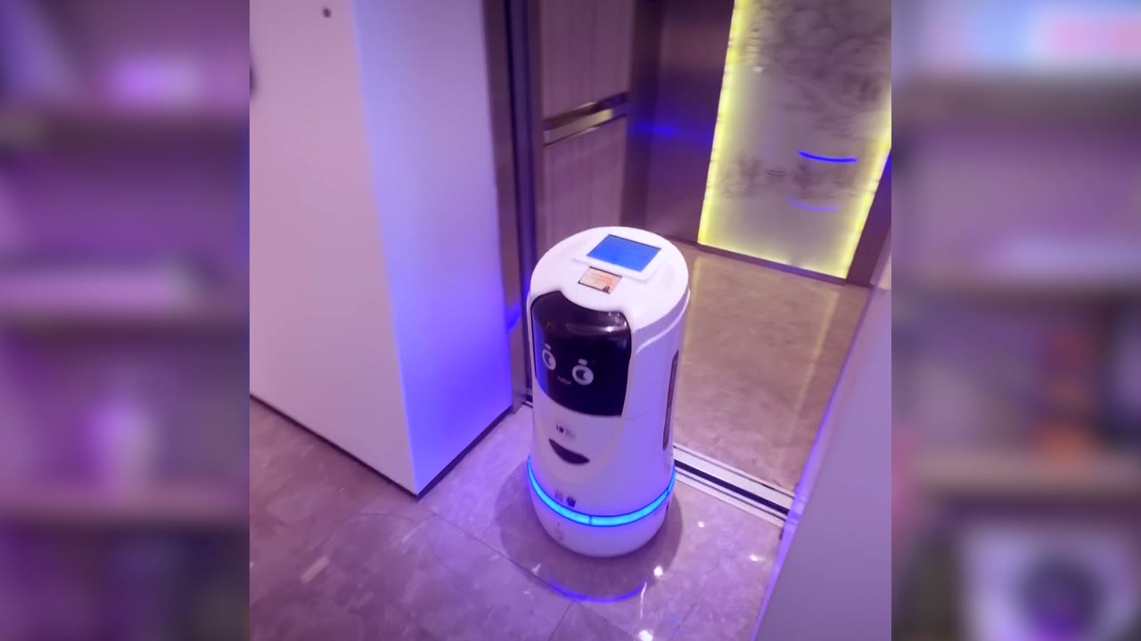 Hotel food delivery robot with blue LED ring waiting at the lift doors