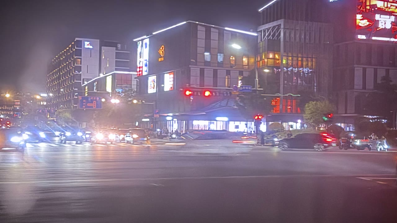 Busy Chinese city intersection at night with traffic and illuminated buildings