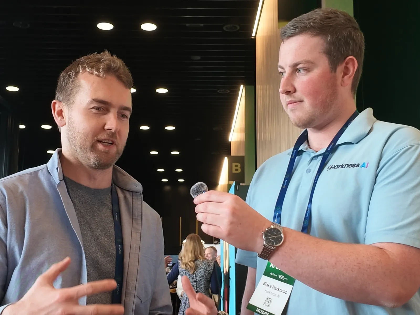 Mike Bayly gesturing as he explains a client project to Blake Harkness at the summit