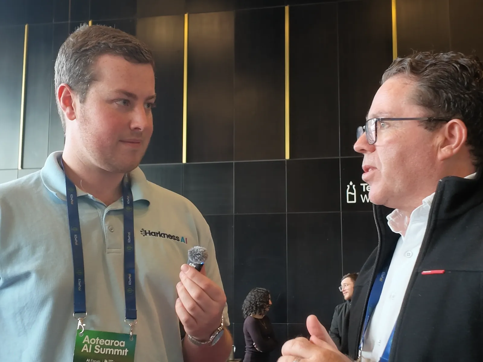 Peter Griffin talking with his hands while Blake Harkness listens, in front of a dark panelled wall
